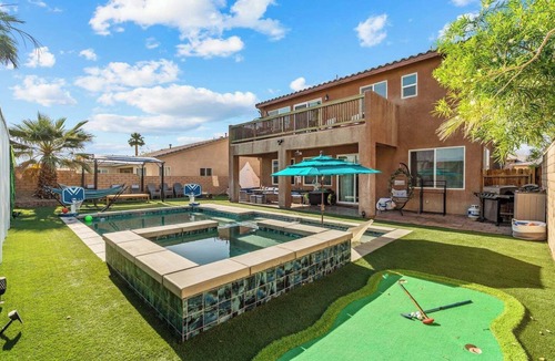 Terra Lago House | This spacious Indio home is designed for families, golf trips, festival weekends, and guests who want built-in entertainment. Enjoy a private saltwater pool, free spa, golf simulator, poolside cinema, game room, glamping yurt, hammocks, and karaoke.