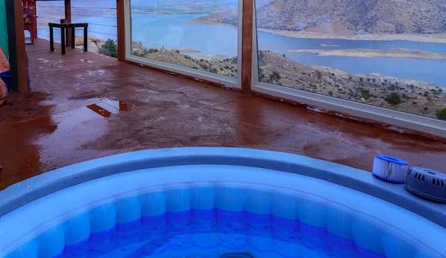 High on a mountainside with a hot tub on a deck.